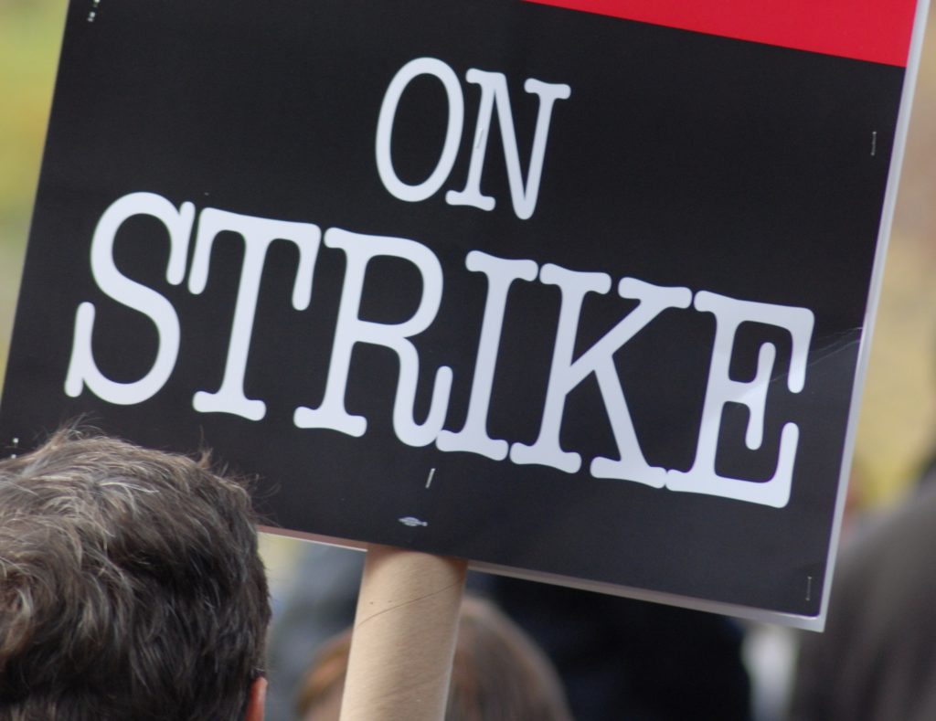 Image of a placard that says 'ON STRIKE'