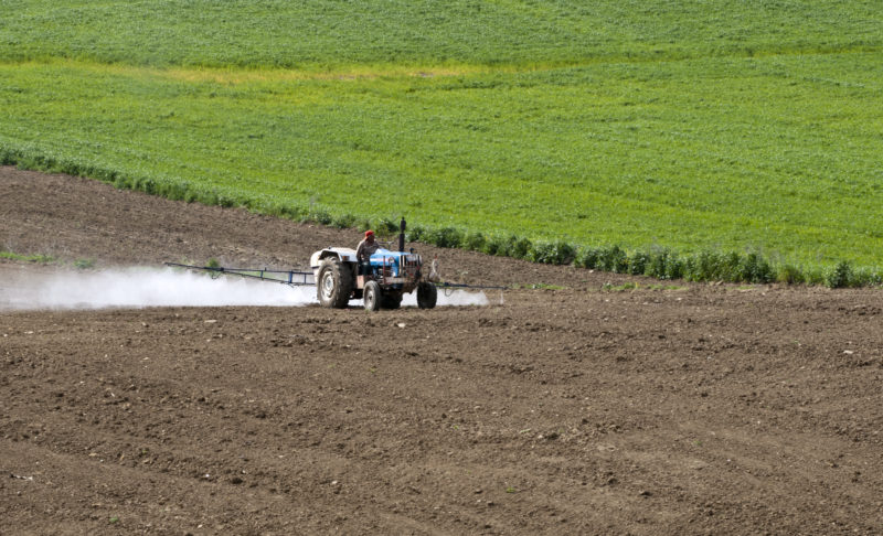 Farmer spraying crops with pesticide