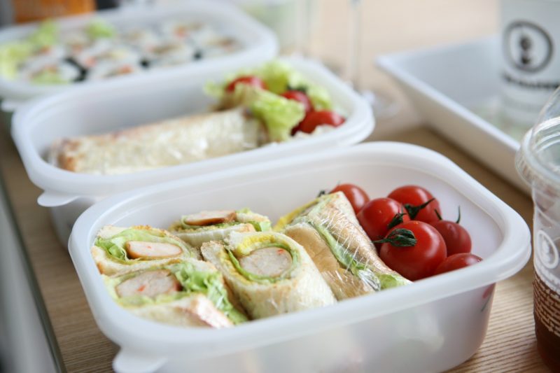 Image of school lunchbox containing wraps and tomatoes 