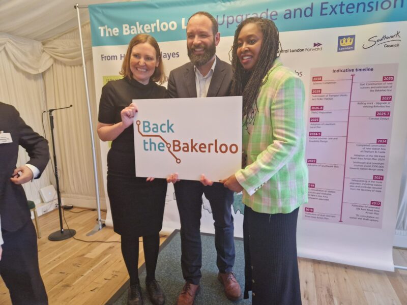A picture of Vicky, stood on a small stage, wearing a black dress. Stood next to her is Cllr Kieron Williams, Leader of Southwark Council and Chair of Central London Forward. Next to Kieron is stood Dawn Butler, MP for Brent Central. All three are carrying a sign which says 
