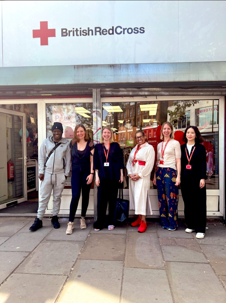Group photo of Vicky with the Lewisham Red Cross staff outside the front of the storefront